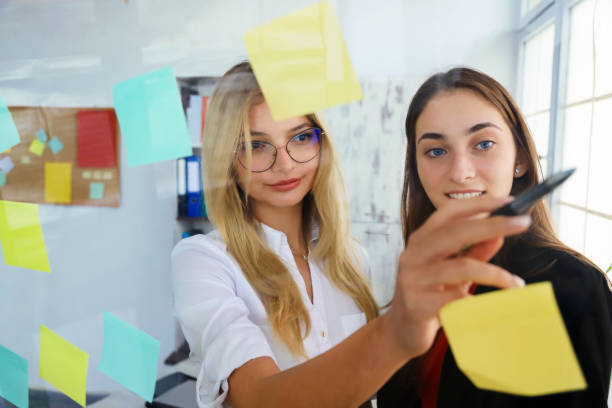 istock Two businesswomen looking at sticky notes 1272391821