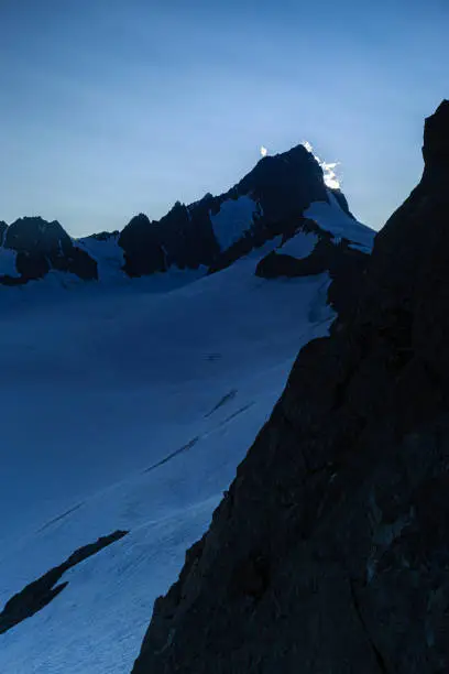 Sun stands behind Finsteraarhorn, in front Studer Glacier, Canton of Valais