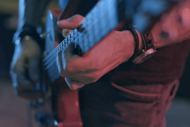 un guitarrista toca un riff de rock con su guitarra en el escenario - riff fotografías e imágenes de stock