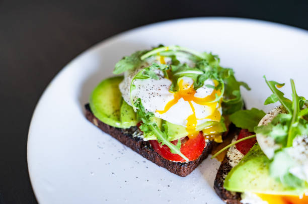 Sandwich with poached eggs on a white plate.