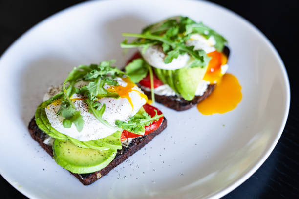 Sandwich with poached eggs on a white plate.