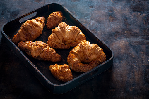 Breakfast tray with pastries croissants homemade bakery on dark background
