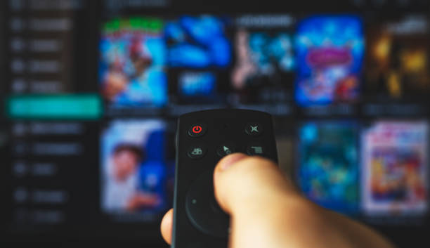 istock Male hand with remote control pointing on Smart TV. 1272403084