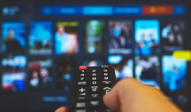istock Male hand with remote control pointing on Smart TV. 1272403086