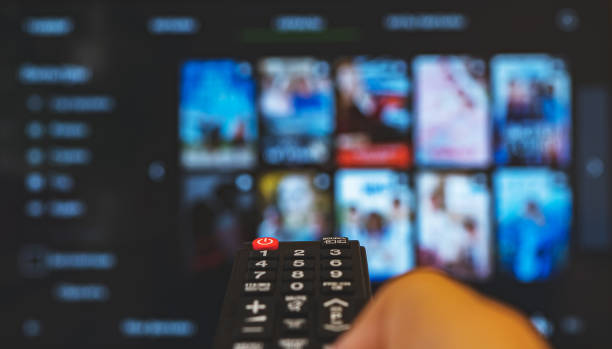istock Male hand with remote control pointing on Smart TV. 1272403089
