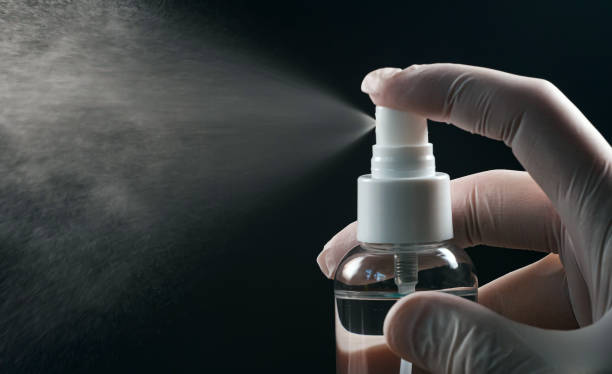 istock Gloved hand using disinfectant spray. Covid-19 prevention. 1272403112