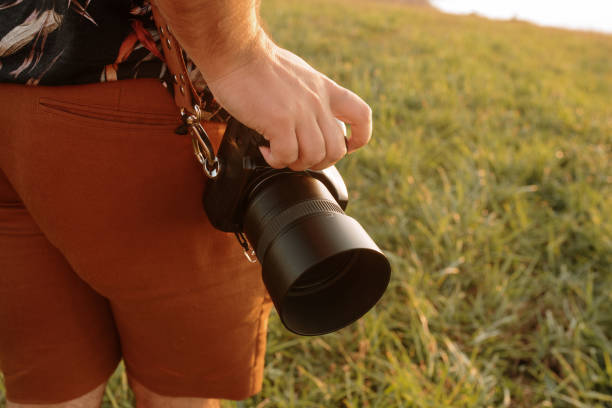 istock Detail of a DSLR camera held by a man 1272406018