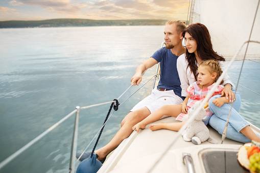 happy family with little child sailing on boat