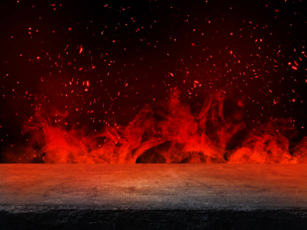 istock Empty stone table top with orange fire or flame and sparkles in dark room. 1272407749