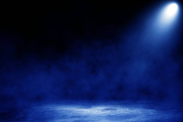 istock Studio dark room with blue lighting effect and fog on concrete floor in black background. 1272408026
