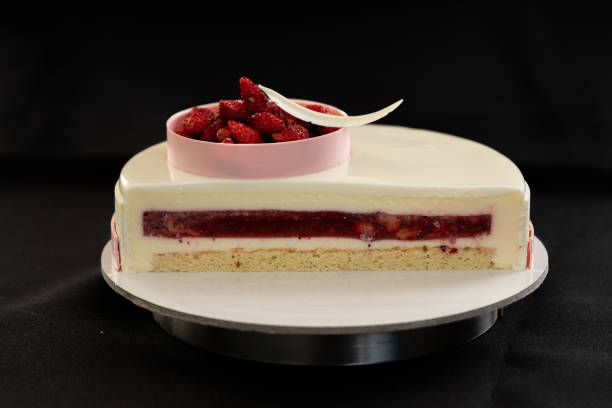 istock Half or slice of white mousse cake isolated on black background 1272408106