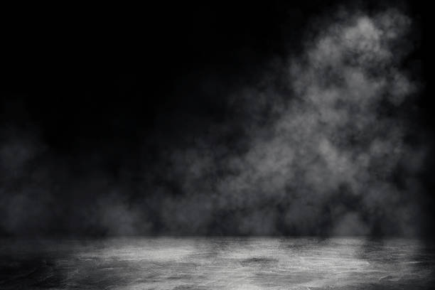 istock Studio dark room with spot lighting and white smoke in black background. 1272408142