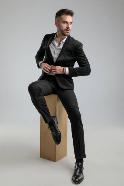 istock cool fashion businessman looking aside, fixing his jacket 1272409842