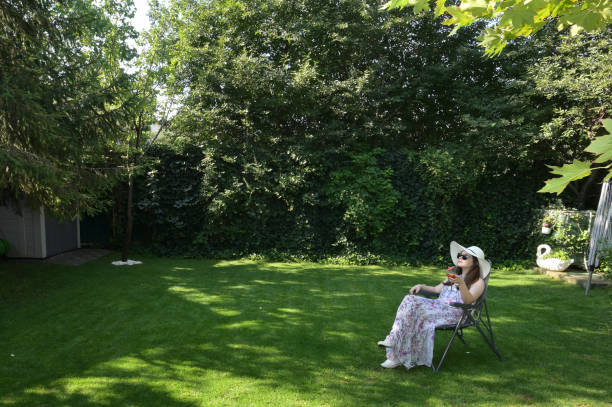 Young woman contemplating, sitting in a green field with hands on her face
