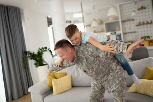 istock Soldier having fun with his son at home. 1272410050
