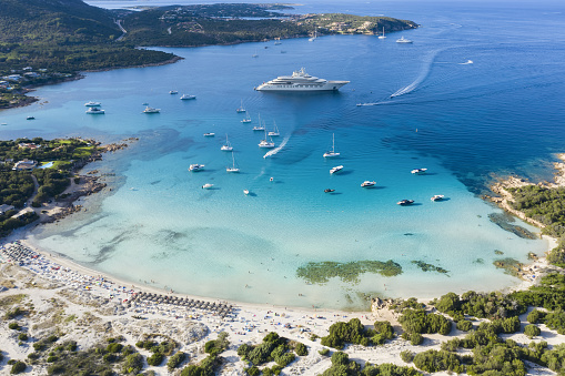 Sardinia, Italy, September 06, 2020. Stunning aerial view of the Grande Pevero beach with boats and luxury yachts sailing on a turquoise, clear water during the Coronavirus, (Covid-19) pandemic. Sardinia, Italy.