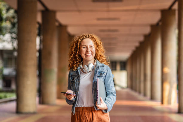 istock Female student with laptop and smart phone 1272411106