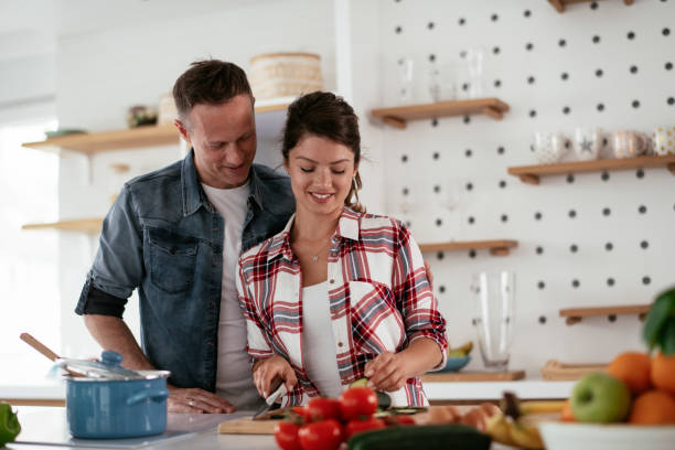 istock Loving couple eating sandwich in kitchen. 1272411288
