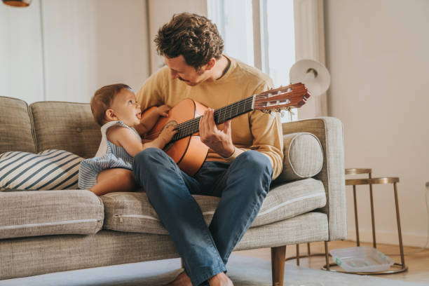 Father Playing Guitar for Baby Father Playing Guitar for Baby father and son guitar stock pictures, royalty-free photos & images