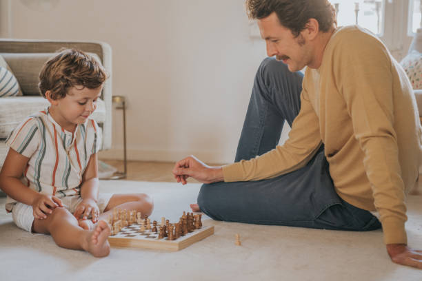 istock Father and son playing chess at home 1272413126