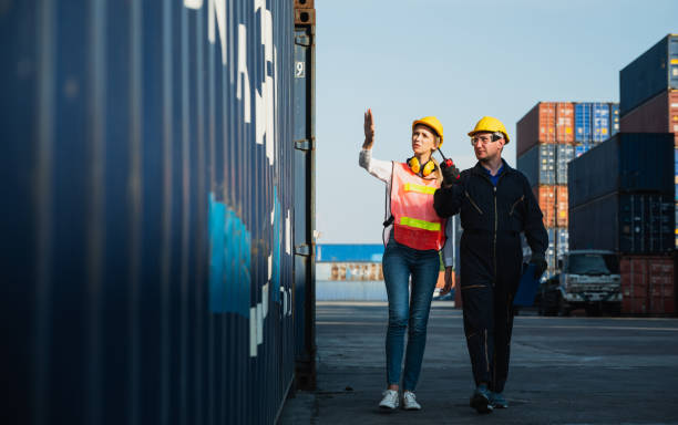 two foreman man & woman worker working checking at container cargo harbor to loading containers. dock male and female staff business logistics import export shipping concept. - harbor cargo container commercial dock container imagens e fotografias de stock