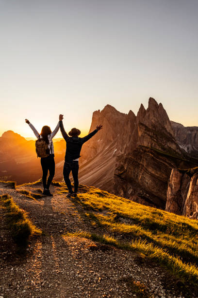 deux touristes heureux saluent le lever du soleil dans les montagnes - european alps women summer outdoor pursuit photos et images de collection