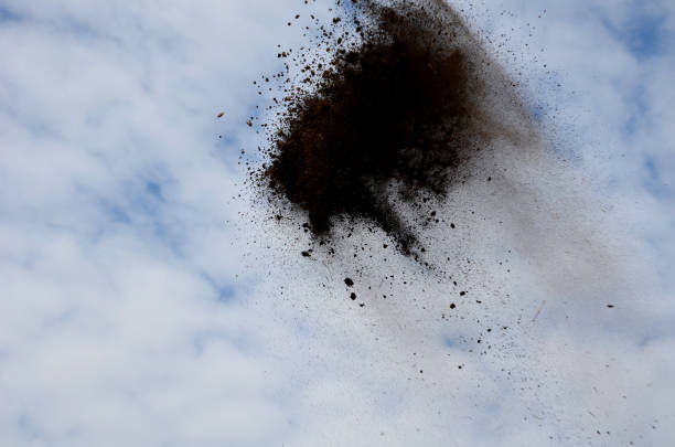 istock manual worker of a stronger figure throws a soil with a shovel, for a better distribution of the soil layer in the garden the soil flies high into the sky that it resembles a bee swarm or meteorite 1272414887