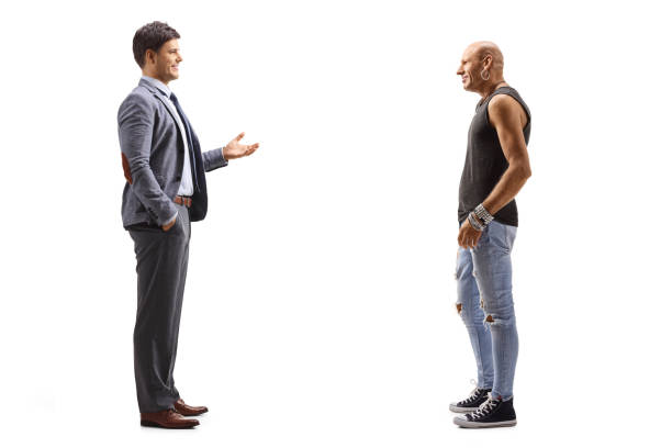 Full length profile shot of a young man in suit and tie talking to a hipster guy isolated on white background