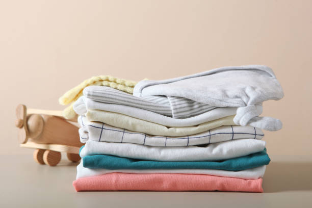 istock a stack of baby clothes on a light background. 1272417480