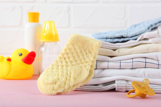 istock a stack of baby clothes on a light background. 1272418554