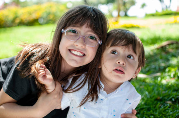 istock Cute sister hugging her little brother 1272420603