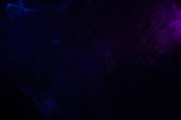 istock Blue and purple smoke and glitter on black 1272423752