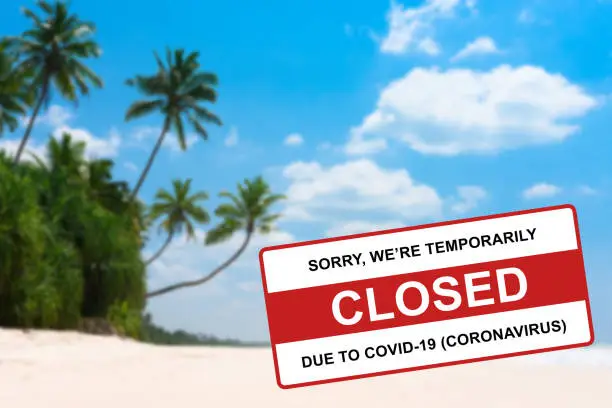 Photo of Tropical beach on island resort closed due to Coronavirus Covid-19 sign