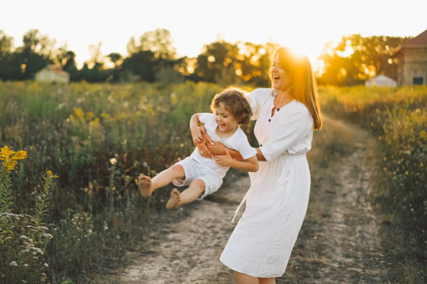 istock Woman playing with her child on the field during sunset 1272424548