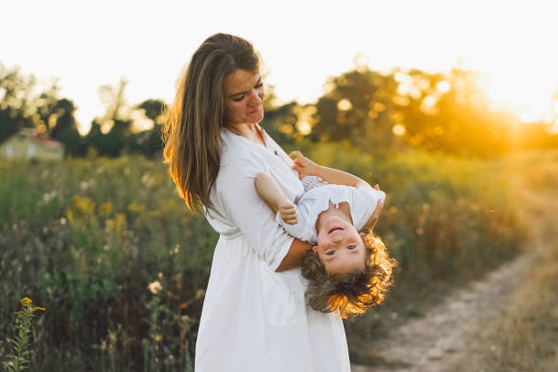 istock Woman playing with her child on the field during sunset 1272424556