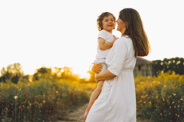 istock Woman playing with her child on the field during sunset 1272425211