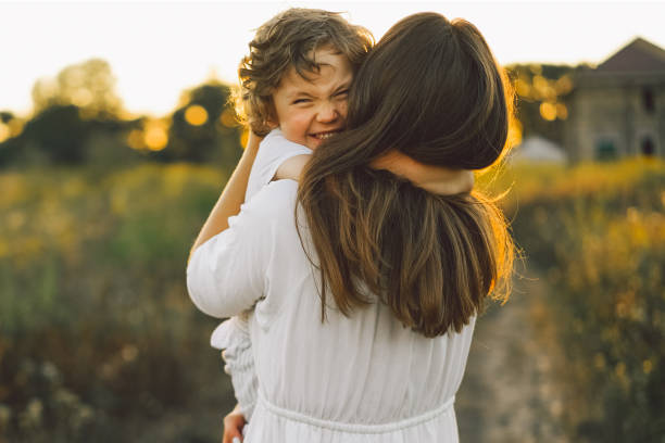 istock Woman playing with her child on the field during sunset 1272425239