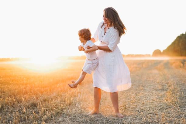 istock Woman playing with her child on the field during sunset 1272425413