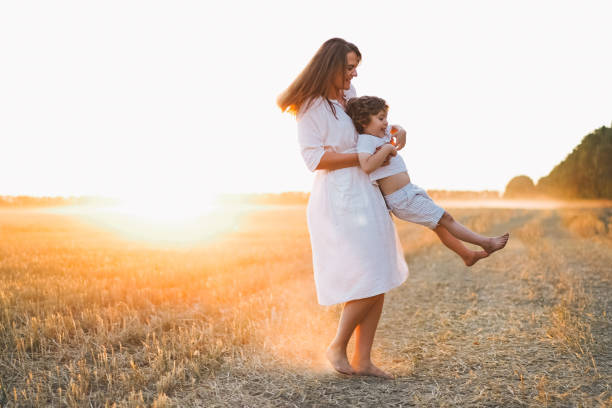 istock Woman playing with her child on the field during sunset 1272425430