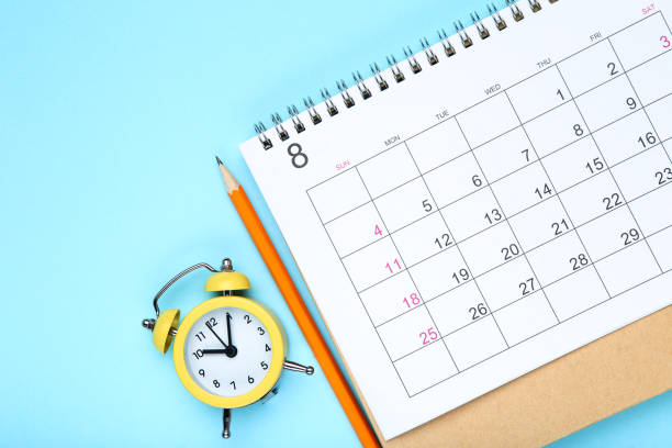 istock Calendar page with pencil and alarm clock on blue background 1272427017