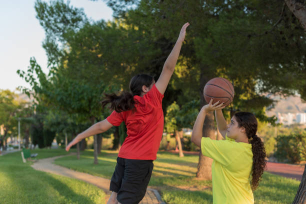 젊은 남성과 여성은 필드에서 농구를합니다. - basketball teenager nature outdoors 뉴스 사진 이미지