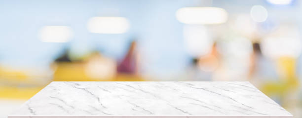 Perspective marble table with people in restaurant blur background.coffee shop with bokeh light,Mockup  banner for display of product