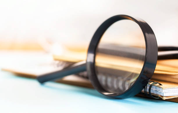 istock Magnifying glass with notebooks and books on the table Education concept 1272432468