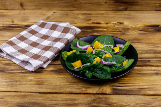 tasty salad with spinach, orange, red onion and sesame seeds on wooden table. healthy food or vegetarian concept - 5898 imagens e fotografias de stock