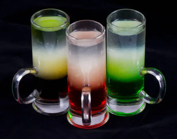 Three alcoholic cocktail shot in a glass on a black background