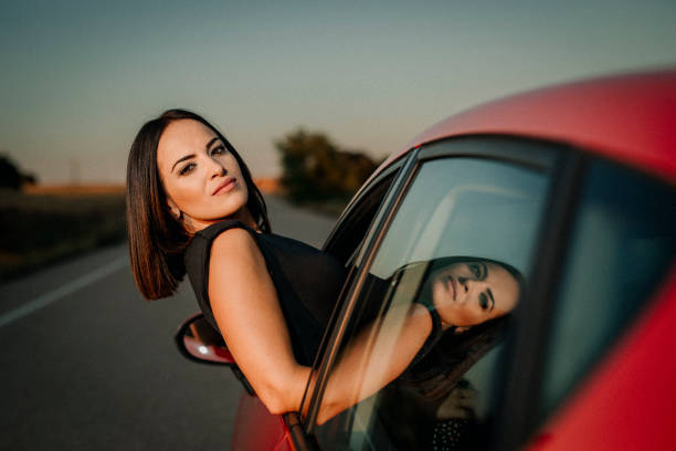 Ritratto di una donna che sbircia dal finestrino dell'auto - foto stock