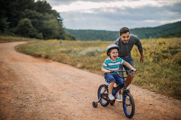 istock Father teaches son to ride a bike 1272439034