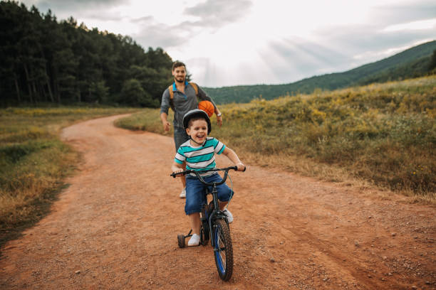istock Father teaches son to ride a bike 1272439250