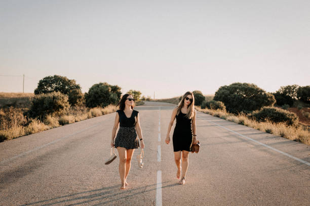 Dos mujeres andando por una carretera - foto de stock
