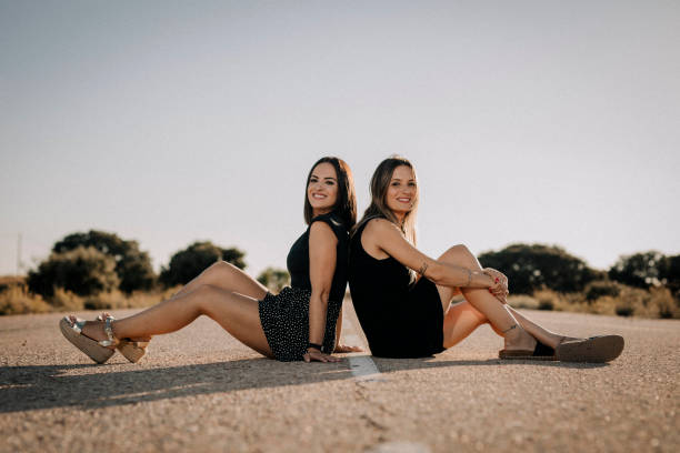 Due belle donne sedute su una strada - foto stock